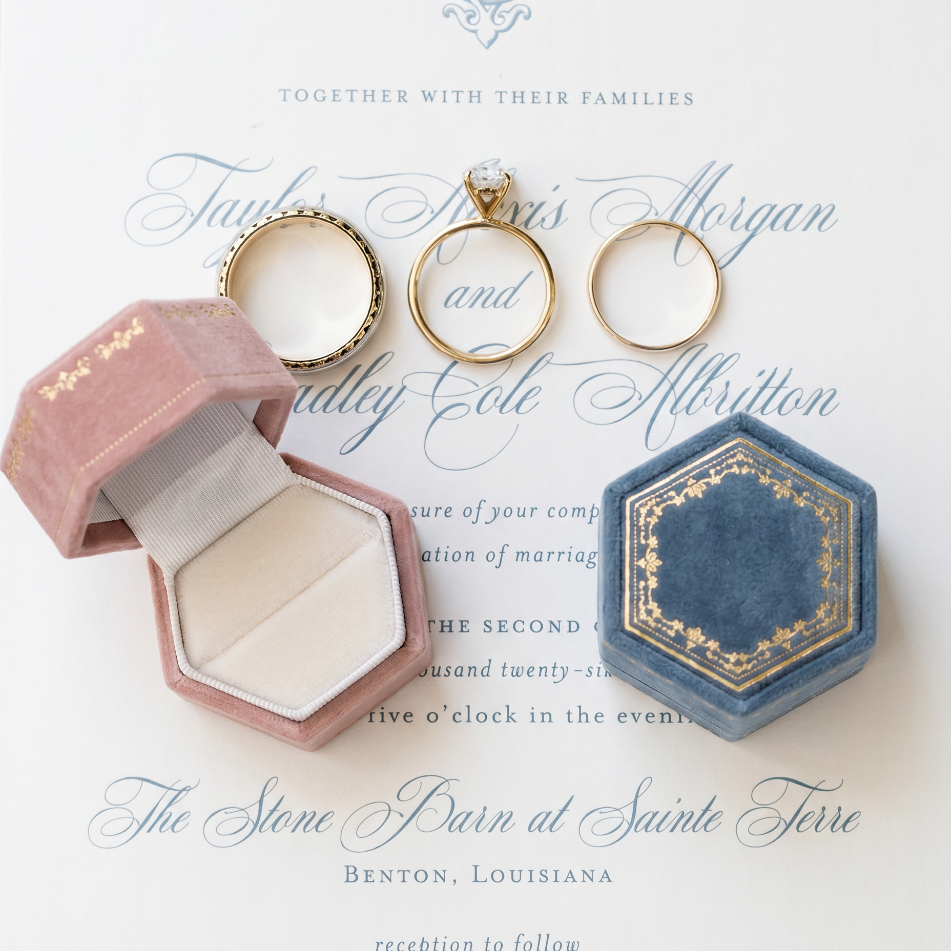 Wedding invitation with the velvet ring boxes in antique rose and antique slate sitting on top. one is open one is closed