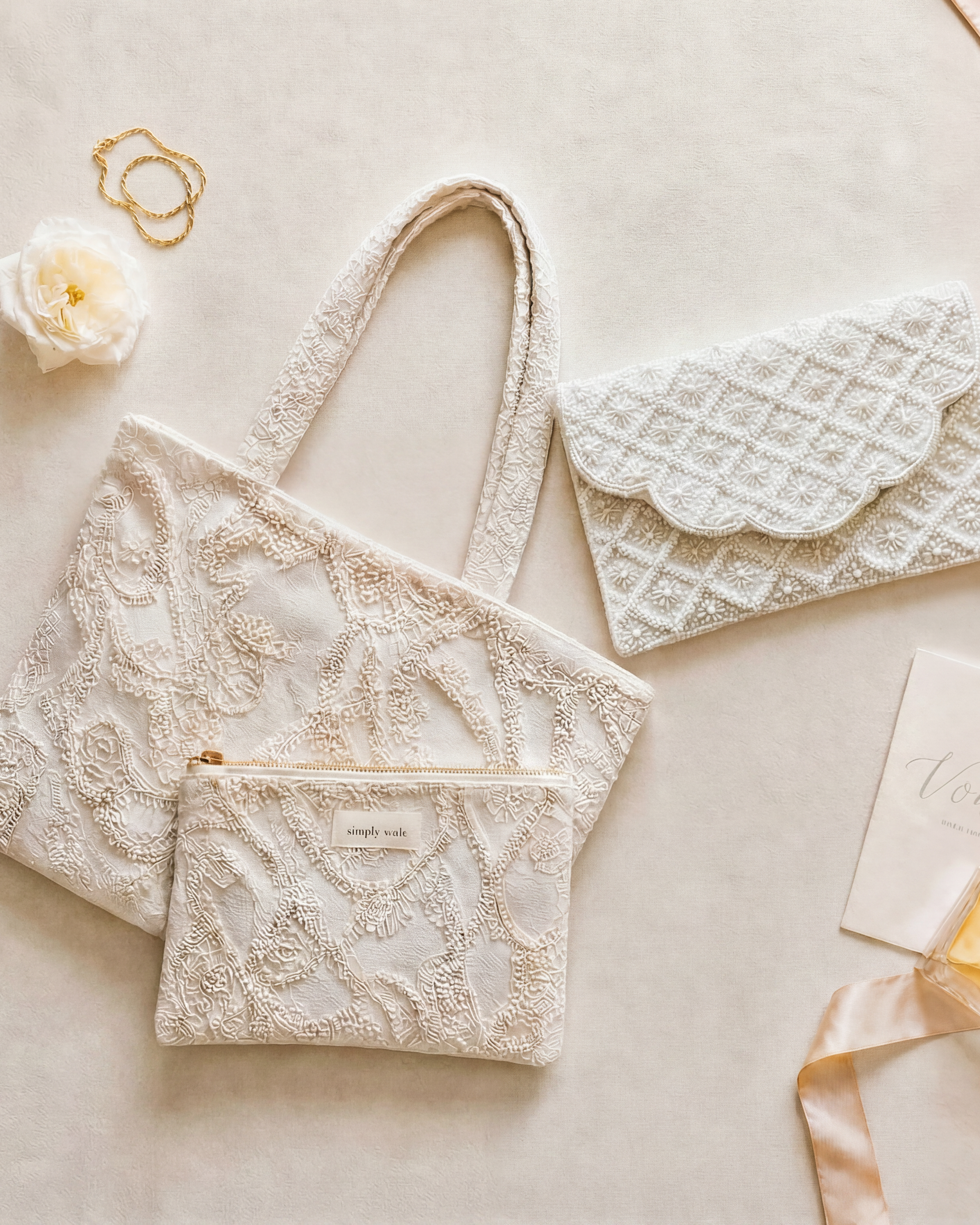 The for keeps beaded clutch and embroidered ivory tote in a wedding day flat lay
