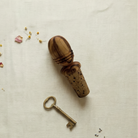 Hand carved olive wood cork stopper with a brass skeleton key and dried flowers
