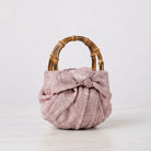 Pink textured ring bag with a bamboo handle on a white background