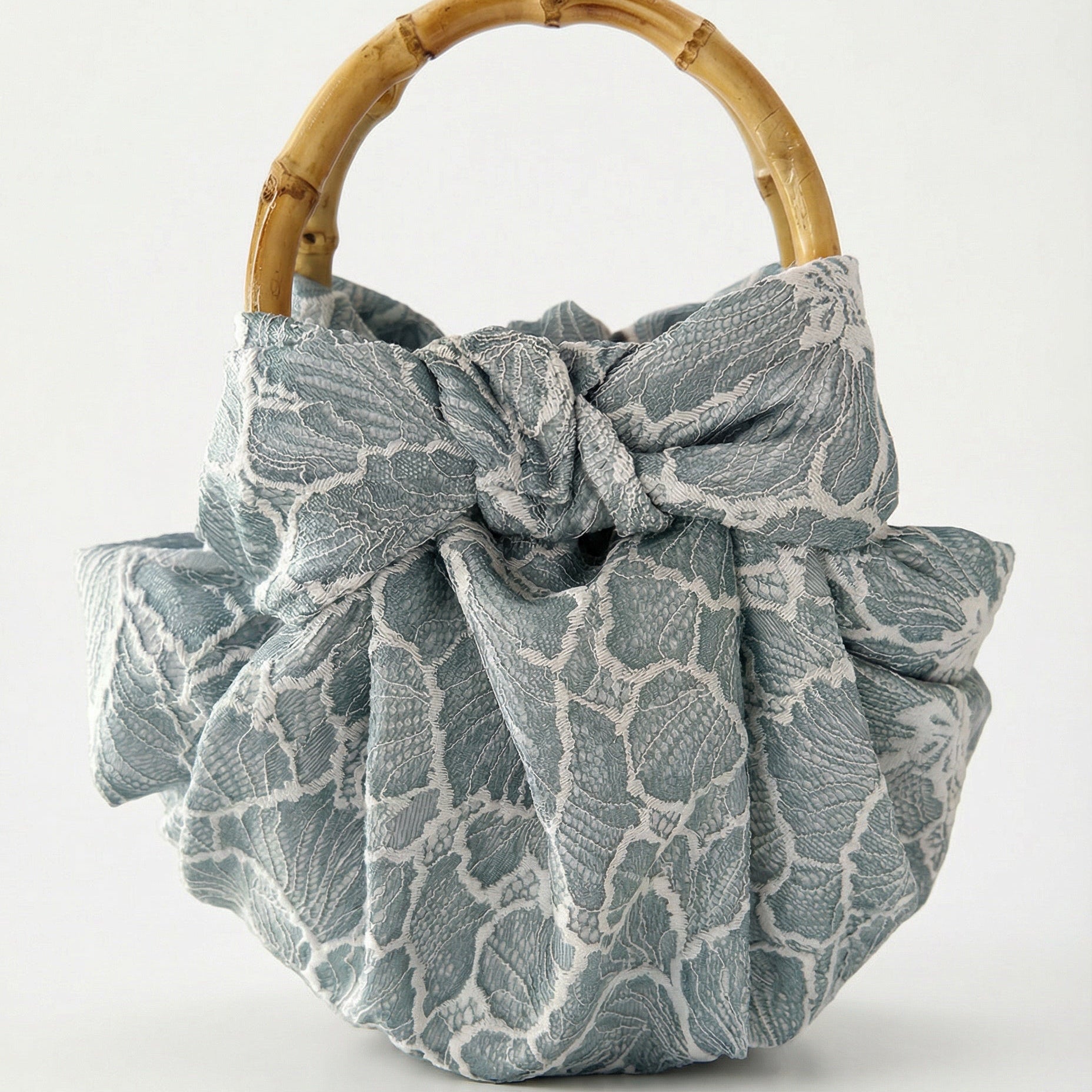 Lace bag with a bamboo handle on a white background