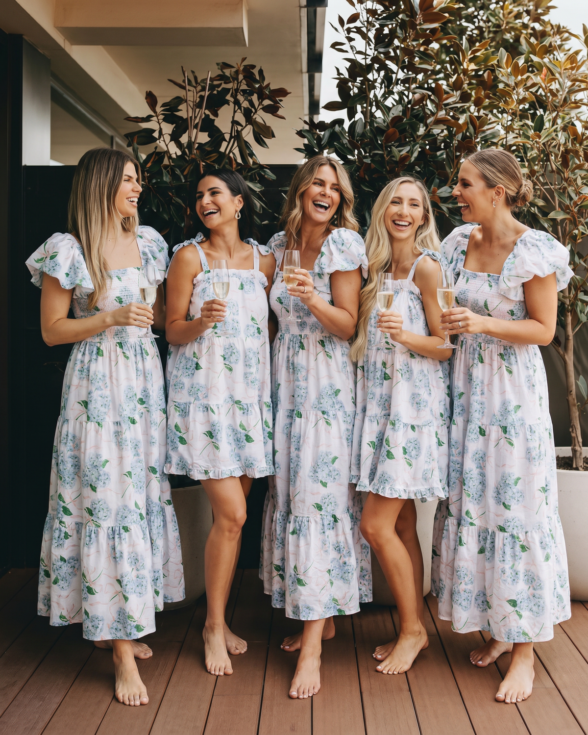 5 women drinking champagne in mix and match blue hydrangea pajamas
