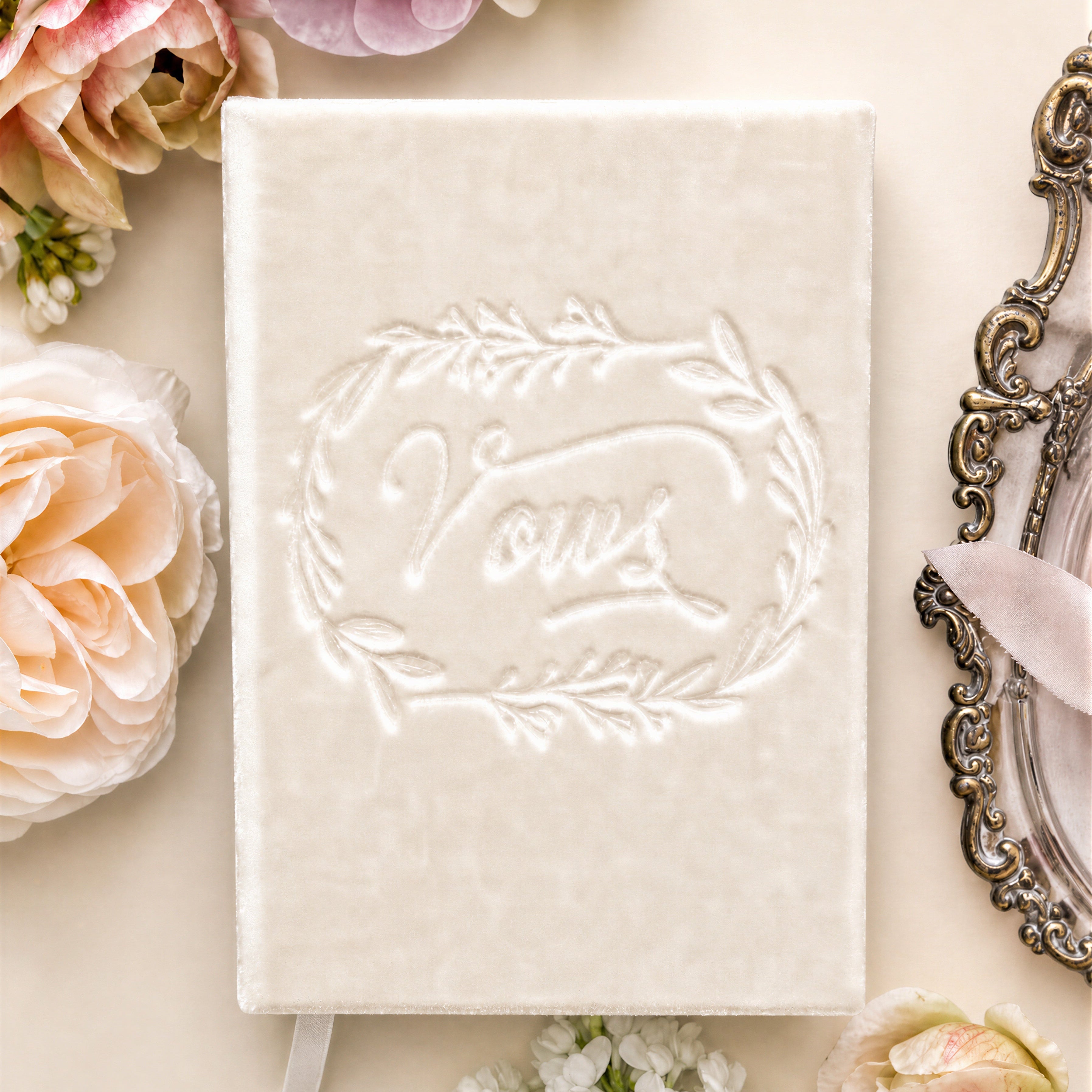 Silk velvet heirloom vow book in ivory on wedding flat lay with anemones and a silver tray