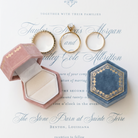 Wedding invitation with the velvet ring boxes in antique rose and antique slate sitting on top. one is open one is closed