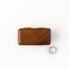 Wooden dual ring box and silver ring on a white background