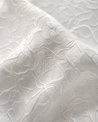 Close-up detail of the exclusive breathable bonded lace fabric a wedding dress bag.